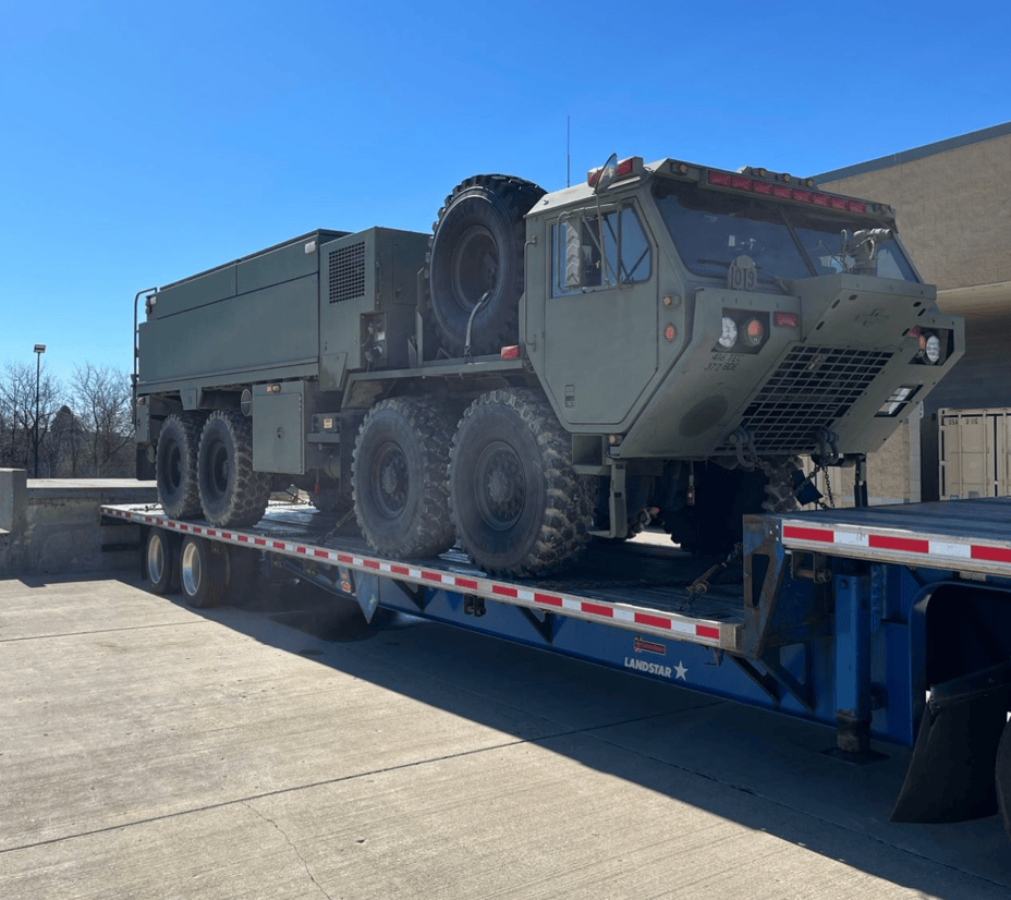 Military vehicle secured on a Nonpareil Logistics flatbed trailer
