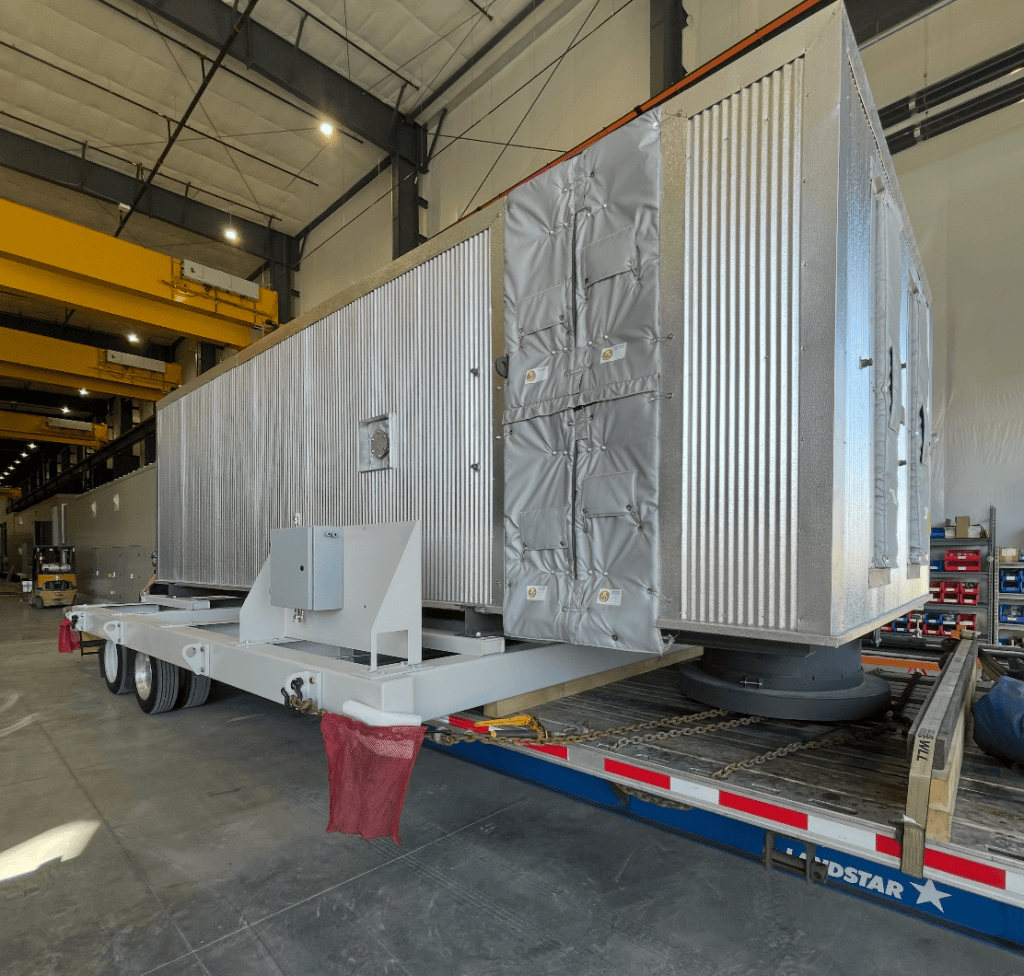 Large industrial equipment secured on a trailer inside a warehouse